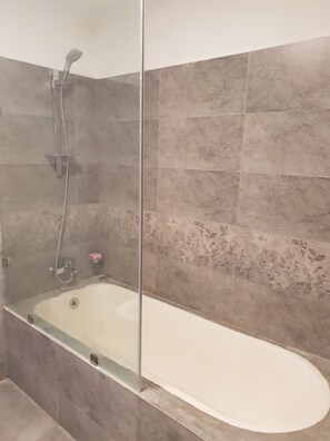 Chambre familiale, Plusieurs lits | Salle de bain | Ensemble baignoire-douche, douche cascade, séchoir à cheveux, pantoufles