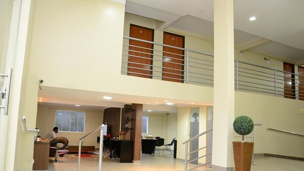A spacious lobby with a high ceiling, a staircase, and a reception desk. - Requinte Hotel (Altamira)