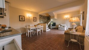 Un amplio espacio de sala con una mesa de comedor, sillas, un sofá y un televisor.