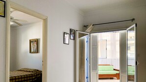 A room with a bed, a door leading to a balcony, and a window with curtains. - House with garden in a residential area 100 m from a magnificent beach (Unknown)