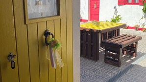 A yellow door with a window, a red door, and a white wall with a sign. - MILL HOUSE 1 - HOLIDAY HOUSE (Santa Cruz - Torres Vedras)