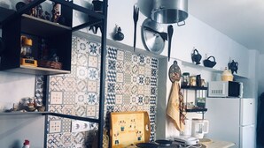 A kitchen with a patterned backsplash, a stove, and various kitchen utensils. - MILL HOUSE 1 - HOLIDAY HOUSE (Santa Cruz - Torres Vedras)