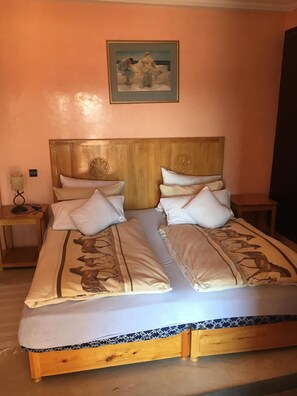 Ein Doppelbett mit Holz-Kopfteil, zwei Nachttische und ein Bild darüber.