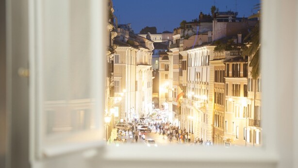 Une vue d’une rue de la ville la nuit, avec des bâtiments de chaque côté.