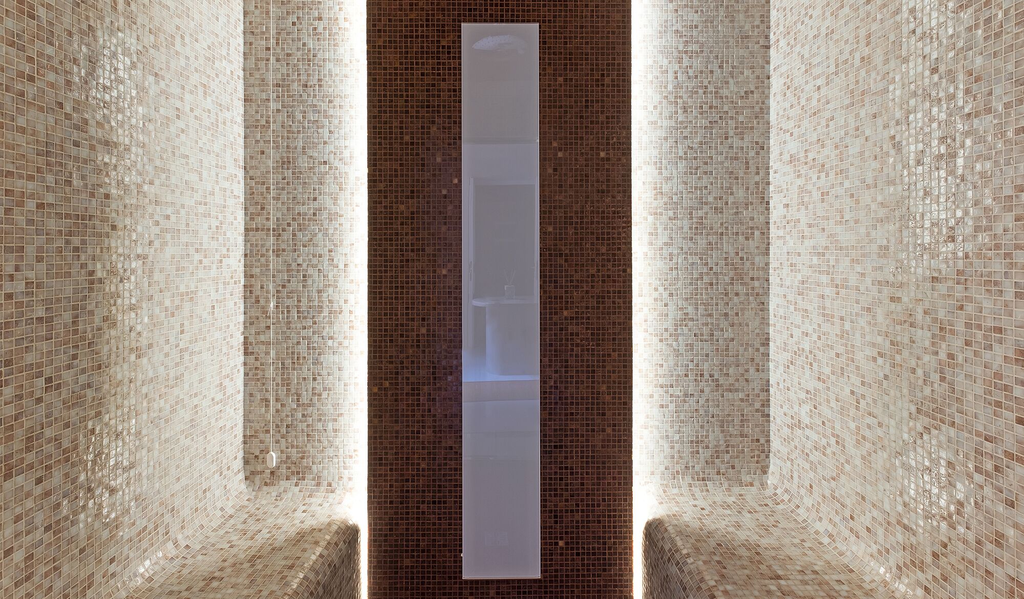 A corridor with a tall, narrow white object in the center, surrounded by patterned walls.