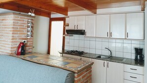 A compact kitchen with white cabinets, a tiled backsplash, a brick oven, and a small window. - "Josef"@MARISOL: 490m to the beach, private pool, A/C, WiFi, dog beach. (Riumar)