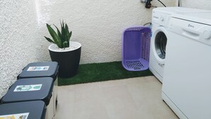 A laundry area with a washing machine, a potted plant, a purple laundry basket, and storage boxes. - "Josef"@MARISOL: 490m to the beach, private pool, A/C, WiFi, dog beach. (Riumar)