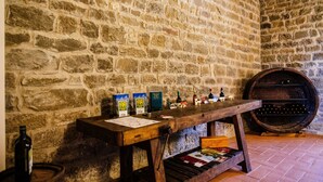 Un muro de piedra con una mesa de madera que muestra botellas y cajas de vino.
