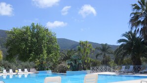 A pool area with lounge chairs and a view of mountains. - 1-bedroom apartment 2/3 people in quiet location (Palinuro)