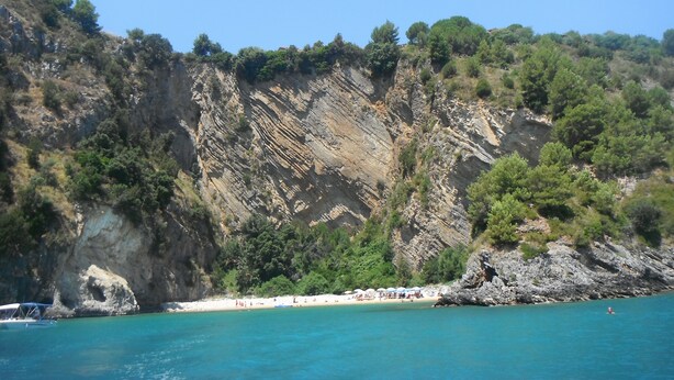A coastal landscape with a rocky cliff, a sandy beach, and clear blue water. - 1-bedroom apartment 2/3 people in quiet location (Palinuro)