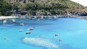 A coastal area with boats on the water, a beach, and a hillside with vegetation. - 1-bedroom apartment 2/3 people in quiet location (Palinuro)