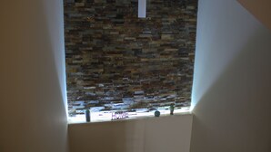 A room with a stone wall and a window with the word "HOME" on it. - Belice Rooms (Salemi)