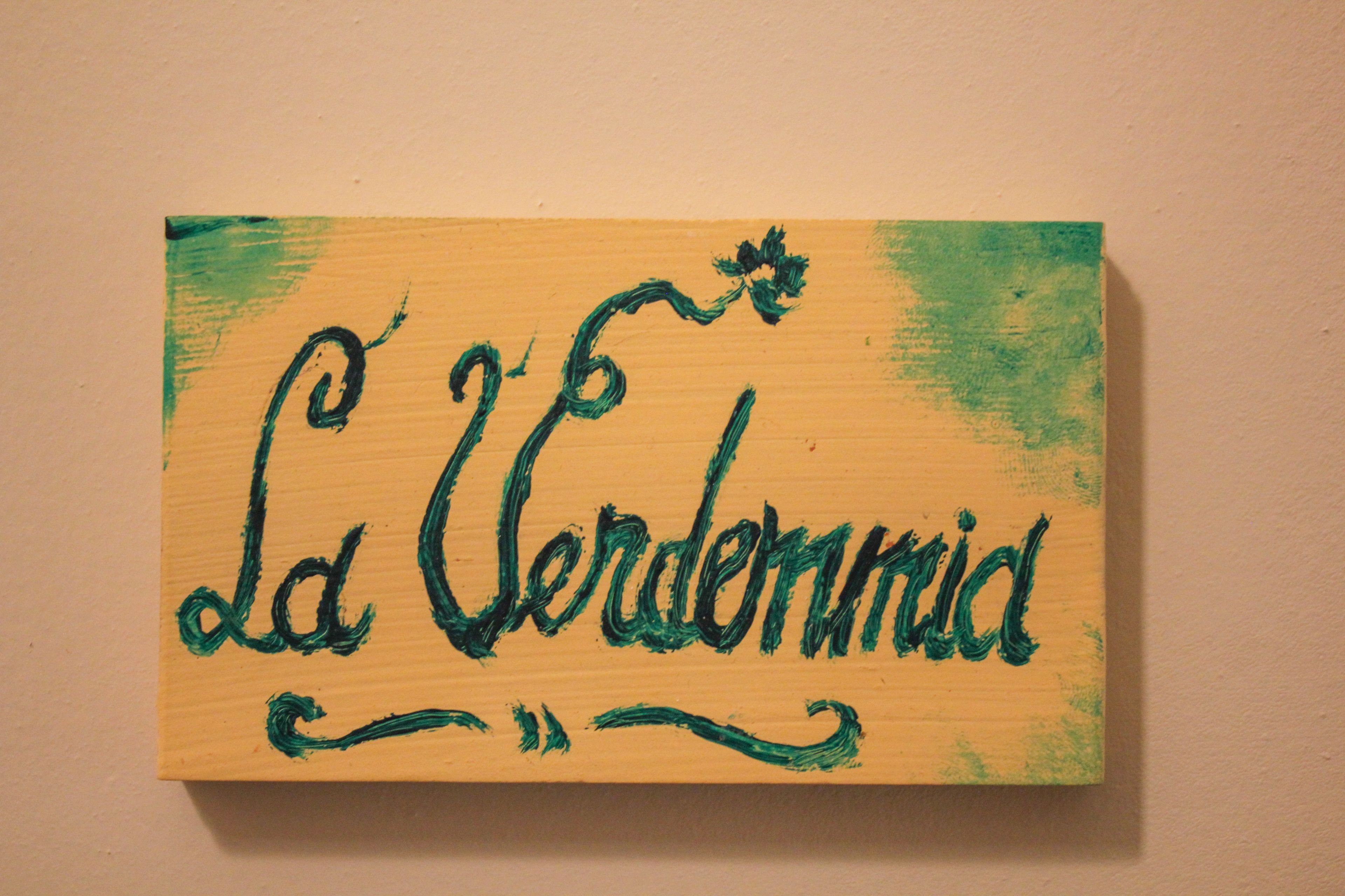Een houten bord met de tekst 'La Verdarmid' in groene letters.
