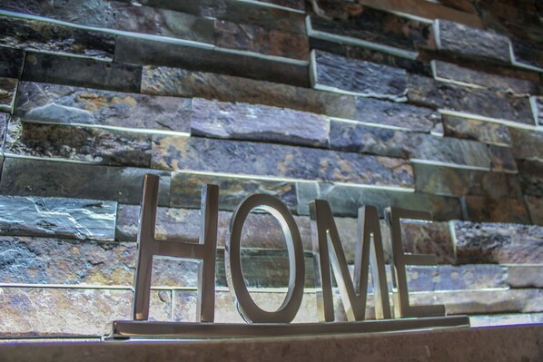 A stone wall with the word "HOME" in metal letters.