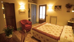 Une chambre à coucher avec un lit, une chaise, une porte et un luminaire fixé au mur.