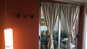 Una habitación con puerta de vidrio corredera, una lámpara de pie y pared roja.