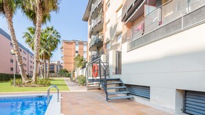 A residential building with a swimming pool, outdoor stairs, and balconies. - 2P53 - Cozy apartment for 4 people with pool located near the center and the beach of Fenals (Lloret de Mar) (Lloret de Mar)