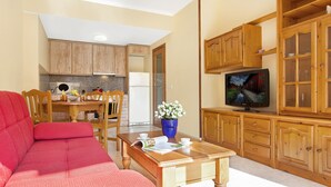 A compact living space with a kitchenette, a dining area, a television, and a sofa. - 2P53 - Cozy apartment for 4 people with pool located near the center and the beach of Fenals (Lloret de Mar) (Lloret de Mar)