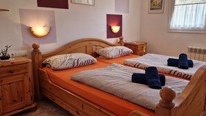 Ein Doppelbett mit Holz-Kopfteil, zwei Nachttische und ein Beistelltisch.