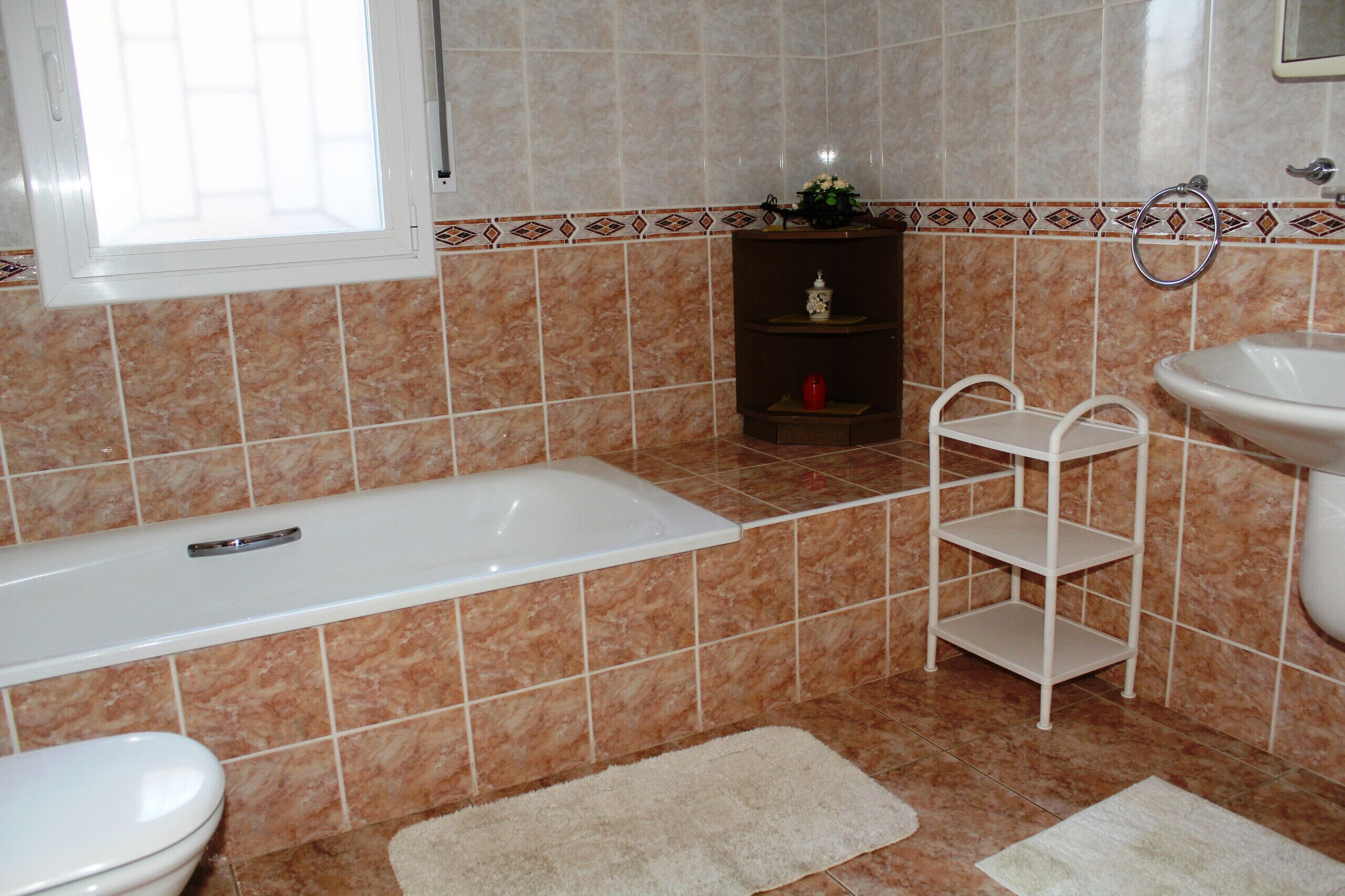 A bathroom with a bathtub, toilet, and sink.