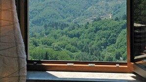 A large window with a clear view of a forested valley and distant hills. - Casa Afra, nestled in the peaceful hills near Lucca, with breathtaking views (Pescaglia)