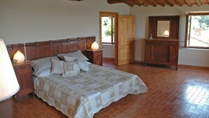 A bedroom with a wooden bed, nightstands, a dresser, and a mirror. - Casa Afra, nestled in the peaceful hills near Lucca, with breathtaking views (Pescaglia)