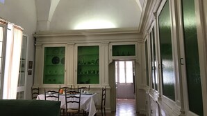 A dining area with a high arched ceiling, white walls, and green-tinted glass cabinets. - Casa PORTATERRA, Antica Dimora for a peaceful stay in the heart of Salento (Scorrano)
