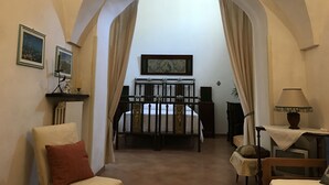 A room with a bed, a chair, a table, and a painting on the wall. - Casa PORTATERRA, Antica Dimora for a peaceful stay in the heart of Salento (Scorrano)
