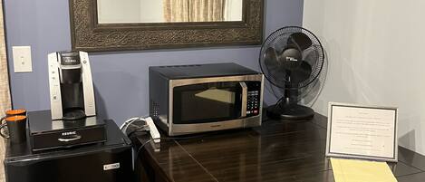 A compact kitchenette with a coffee maker, microwave, and a small refrigerator.