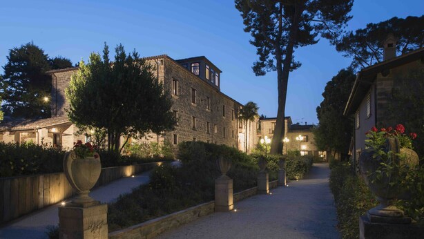A stone building with a traditional design, a paved pathway, and surrounding greenery. - Villa Teloni, your exclusive place w/private pool (San Severino Marche)