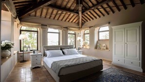 A bedroom with a large bed, a wooden ceiling, a white wardrobe, and a window with curtains. - Villa Teloni, your exclusive place w/private pool (San Severino Marche)