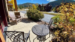 A patio with outdoor seating, a stone fireplace, and a view of a mountain range. - Ground-Floor Unit w/Views, Close to Trails & Golf! (Keystone)
