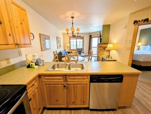Fully equipped kitchen with double sink, stove, and dishwasher, perfect for meal preparation and dining.