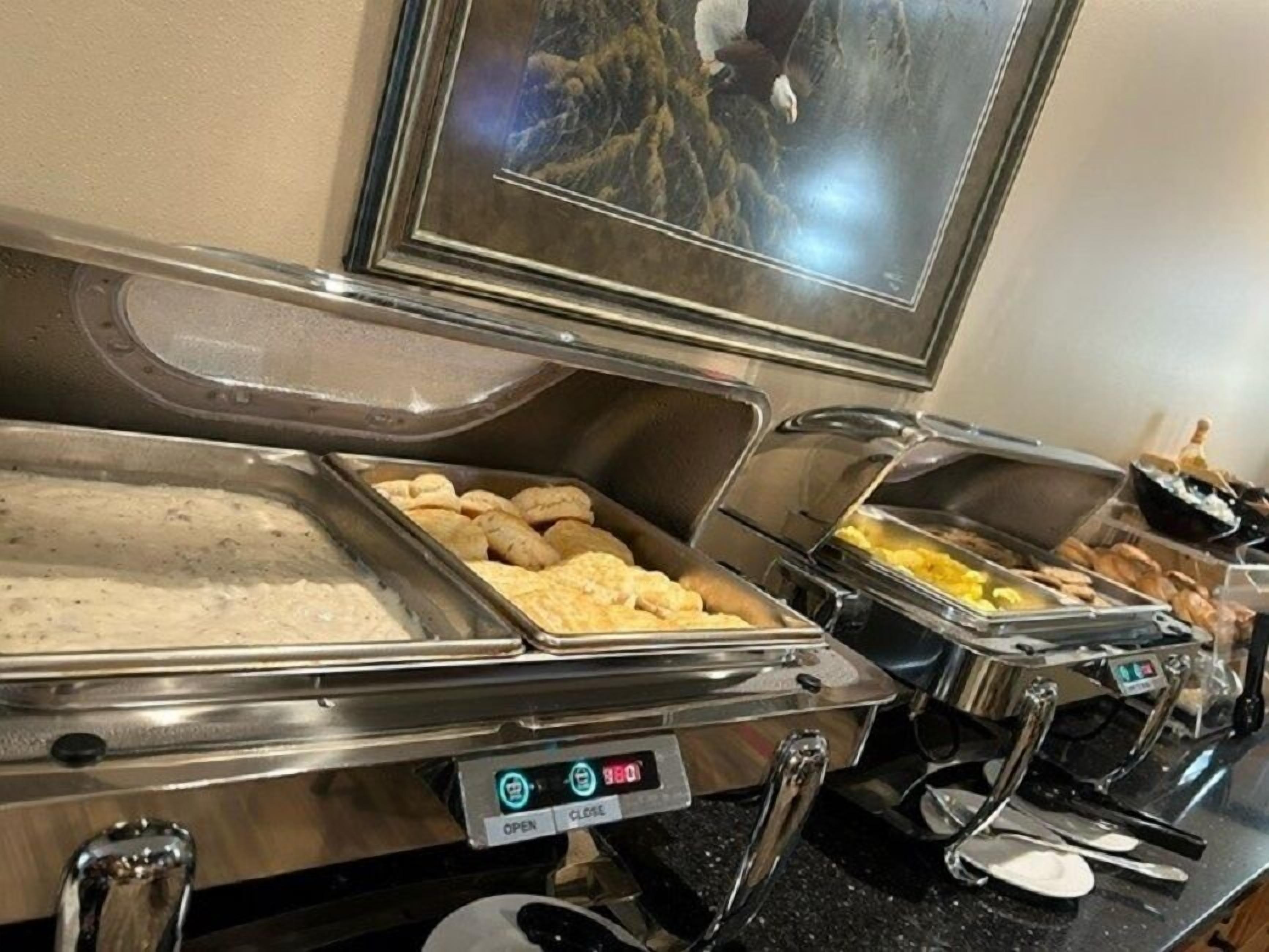 A buffet setup with various food items in trays, including what appears to be pastries and possibly some seafood.