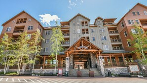 Ein mehrstöckiges Hotel mit markantem Eingang, Steinstufen und einer Holzfassade.