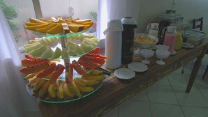 Un bufé con diversas frutas y bebidas.