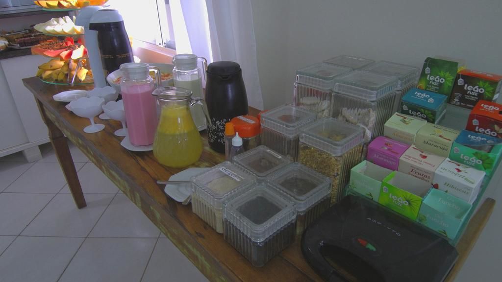 Una mesa de buffet con distintos alimentos, bebidas y recipientes.
