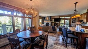 A spacious kitchen with a dining area, large windows, and a fireplace. - Exquisite 3 Bdrm Unit, Mtn Views, Summer Festivals (Keystone)
