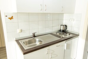 Køleskab, kogeplade, kaffe-/temaskine, elkedel