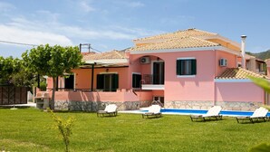 A two-story house with a swimming pool and outdoor seating. - Villa Sonia (Anthemis villas) - Private Pool, private BBQ, playground for kids! (Kariotes)