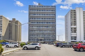 A modern multi-story building with a flat facade and large windows.
