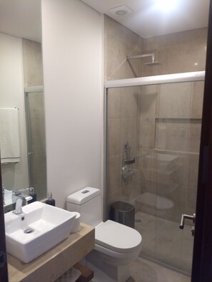 A modern bathroom with a glass-enclosed shower, a white sink, and a toilet. - Nuevo Lujoso Depto Residencial Queretaro (Querétaro)