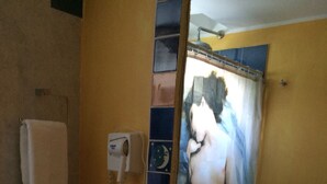 Ein Badezimmer mit Schachbrettboden, einem großen Spiegel, einem Telefon und einer Obstschale.