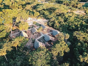 An aerial view of a rural area with scattered buildings surrounded by dense forest. - Tava Glamping Cerro (San Bernardino)