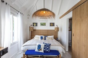 Una camera da letto con un letto grande, un lampadario e vista sul bagno.