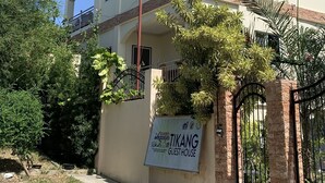 Un bâtiment à deux étages sur lequel on peut lire l’inscription « TIKANG GUEST HOUSE ».