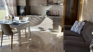 Una cocina moderna con comedor, un sofá y vistas al exterior.