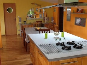Une cuisine compacte dotée d’un îlot central, de meubles en bois et d’un petit coin repas.