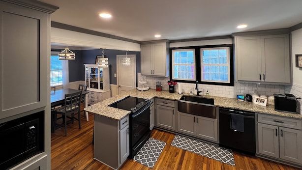 A modern kitchen with granite countertops, stainless steel appliances, and a built-in oven.
