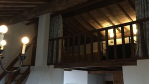A rustic interior with exposed wooden beams, a balcony with curtains, and a staircase. - Apartment in Farmhouse for Families with Pool (Porchiano del Monte - Amelia)